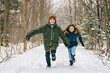 Little girl and boy in winter season running together