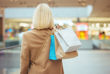Woman In Shopping. Happy Woman With Shopping Bags Enjoying In Shopping. Consumerism, Shopping, Lifestyle Concept. Black Friday Sales Concept. Beautiful Girl Is Holding Shopping Bags, Rear View