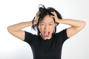 Young attractive south east asian woman pose face expression emotion on white background angry shout hand in hair mad