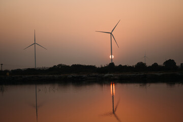 Wall Mural - View of the sunset at the lake with windmills on the hills at Wankaner, Gujarat, India