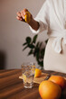 © Dina - woman making lemon water in the kitchen at home - healthy eating and lifestyle