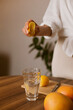 © Dina - woman making lemon water in the kitchen at home - healthy eating and lifestyle