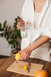 © Dina - woman making lemon water in the kitchen at home - healthy eating and lifestyle