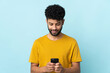 © luismolinero - Young Moroccan man isolated on blue background sending a message or email with the mobile