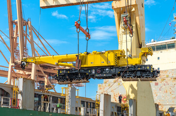 Wall Mural - The crane is lifting, the bogie crane, the train. new car off the boat