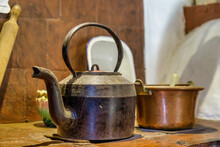 Old Iron Kettle Next To A Copper Pot On Old Stove