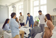 © Studio Romantic - Business people having a work meeting in a modern office. Group of men and women having a serious discussion. Corporate leader talking to a team of young, mature and senior employees and coworkers
