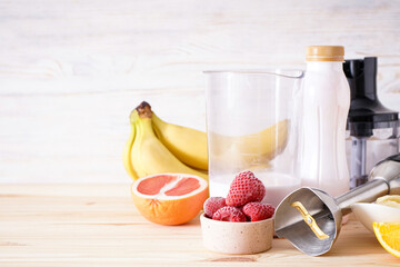 Immersion hand blender with sliced fruit on a wooden background, place fo text.