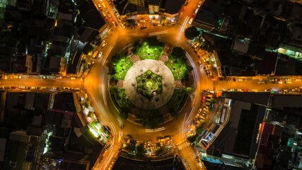 Wall Mural - Top down aerial time lapse view of night traffic at roundabout in central Bangkok, Thailand, zoom out.