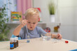 © Olleg1 - little boy child blonde play chemical experiments to sit at the table at home.