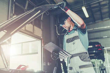 Wall Mural - Caucasian Car Mechanic Electronic Elements Technician Checking on an Issue