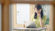 © metamorworks - カフェでノートパソコンを使って仕事をする女性