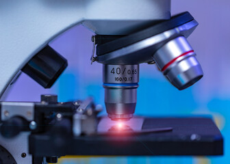 Sticker - Closeup studio shot of magnifier zooming lens microscope camera placing on working table in hospital laboratory full of glassware equipment test tube rack Erlenmeyer flask beaker and computer monitor