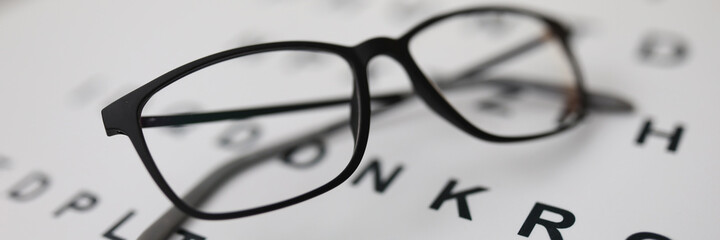 Canvas Print - Glasses for sight lie on the table on the alphabet