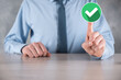 © Ivan - Hand holds green icon Check mark,Check Mark Sign, Tick Icon,right sign,circle green checkmark button,Done.On dark background.Banner.Copy space.Place for text.