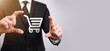 © Ivan - Business man hold in hand shopping cart icon.Shopping online concept.basket hologram. Online shopping, online store application in a smartphone. Digital Marketing Online