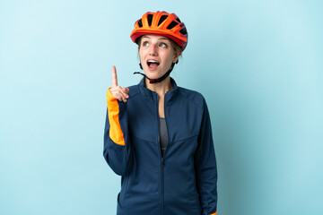 Canvas Print - Young cyclist woman isolated on blue background thinking an idea pointing the finger up