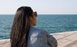 © Den-Dubinko - Asian young lady sitting and enjoying the sea view