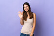 © luismolinero - Young caucasian woman isolated on purple background saluting with hand with happy expression