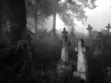 Dark Ancient Cemetery In The Fog. Crosses And Graves In The Old Abandoned Cemetery. Place Of Burial. Black White Photo.