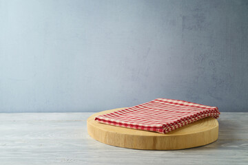 Wall Mural - Empty wooden log  with red checked tablecloth on rustic table over gray wall  background.  Kitchen mock up for design and product display.