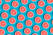 Minimal fruit pattern with grapefruit on blue  background. Creative  summer mood. Healty concept. Organic fruit. Flat lay. Trendy social mockup or wallpaper.