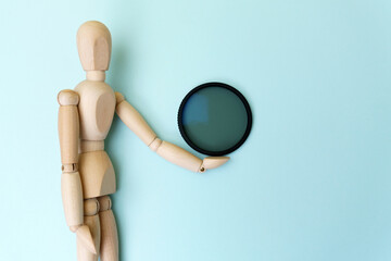 Canvas Print - Polarizing filter in hand, an accessory for the photographer. Blue background copy space