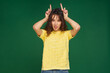 Funny young girl make horns by fingers, making faces, showing tongue, having fun, grimacing, fooling, teasing