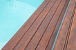 Detail of swimming pool coping and cover constructed by cumaru wood deck, hardwood decking texture next water