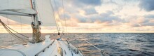 Yacht Sailing In An Open Sea At Sunset. Close-up View Of The Deck, Mast And Sails. Clear Sky After The Rain, Dramatic Glowing Clouds, Golden Sunlight, Waves And Water Splashes, Cyclone. Epic Seascape