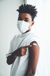 Leinwandbild Motiv African American teenager showing COVID-19 vaccine bandage merrily in concept of coronavirus vaccination program to vaccinate citizen .