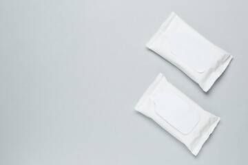 Wall Mural - Wet wipes flow packs on light grey background, flat lay. Space for text