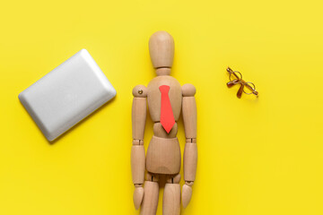 Mannequin with tiny laptop and eyeglasses on color background