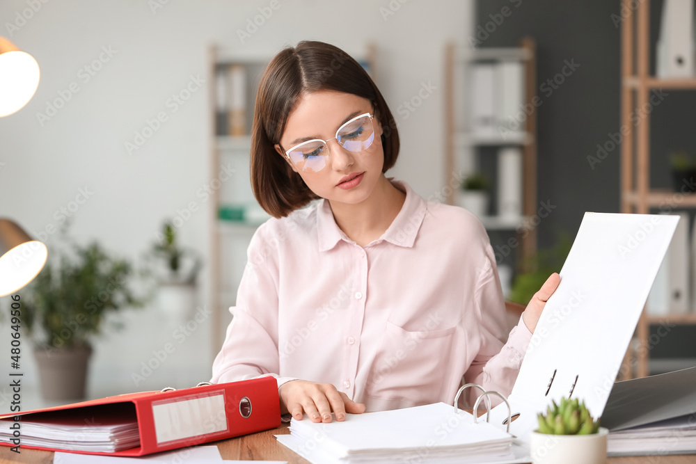 Young woman working with documents in office
