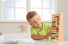 Adorable Little Boy Learning Math With Abacus At Home