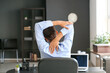 Young businessman stretching his spine while working in office
