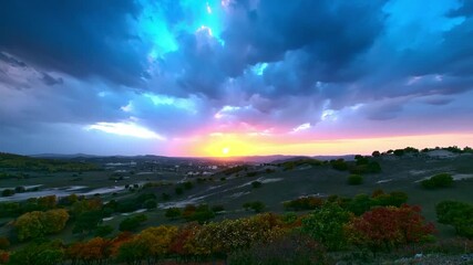 Wall Mural - Time-lapse of dark clouds flowing over the grass at sunset