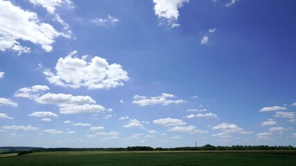 Wall Mural - Time-lapse of clouds changing shapes and disappearing over wheat fields in village in France