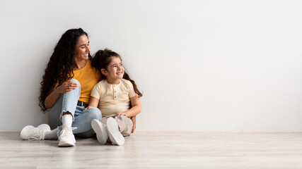 Wall Mural - Family Advertisement. Happy Mom And Little Daughter Looking Aside At Copy Space