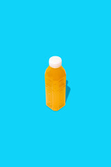 Wall Mural - Yellow detox juice drink in a bottle on a blue background.