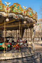 Old French Carousel In A Louvre Park On A Sunny Winter Day. Traditional Fairground Vintage Carousel. Merry-go-round With Horses. Paris, France.