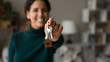 © fizkes - Close up young happy blurred woman showing keys to camera, feeling excited of purchasing own apartment or moving into new renovated dwelling, real estate agency professional service or tenancy concept