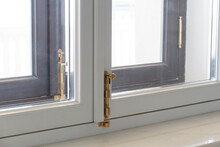 Close-up Of A Window Frame. White Modern Plastic Windows With Golden Latches.