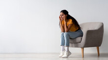 Depression Concept. Upset Worry Young Woman Sitting In Armchair At Home