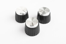 Three Vintage Plastic And Metal Guitar Knobs On White Background
