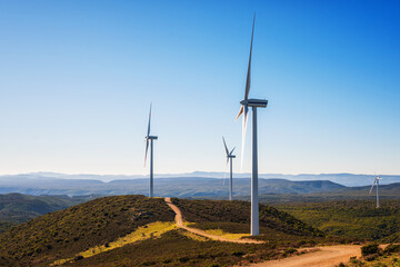 Wall Mural - wind turbines on a beautiful blue sky in a mountain wind farm in sardinia. renewable energy concept,