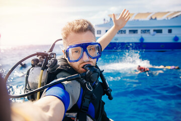 Selfie photo man diver scuba diving blue water sea looking at camera with sun light. Concept travel extreme sport