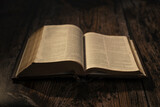 Fototapeta Tulipany - open bible on wooden table, chapter Matthew. contrast atmosphere