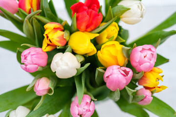  bouquet of colorful tulips stands on a table in a vase