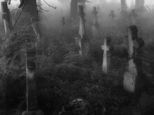 Dark Ancient Cemetery In The Fog. Crosses And Graves In The Old Abandoned Cemetery. Place Of Burial. Black White Photo.